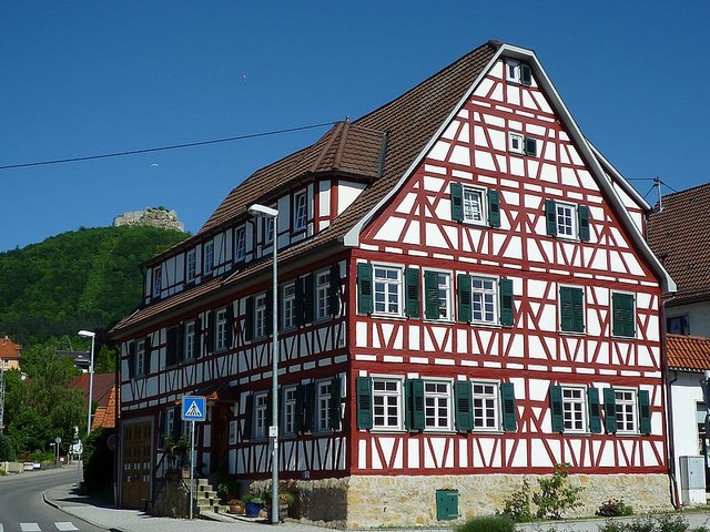 a building in Neuffen with the Hohenneuffen castle on the hill above