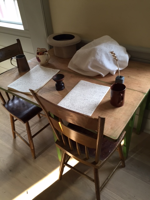Translation table. Replica plates covered by linen cloth on table.